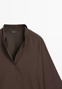 Bruine overhemdu met een casual kraag, gemaakt van een textuurstof en voorzien van lange mouwen. Label zichtbaar in het kraaggebied.