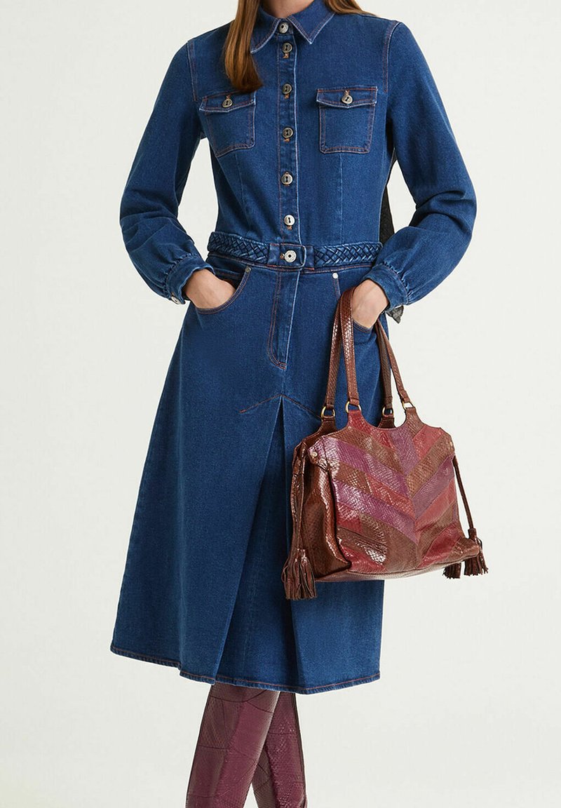 Robe chemise en denim avec fermeture à boutons sur le devant, deux poches poitrine, ceinture tressée et manches longues. Sac à main marron texturé avec motif chevron.