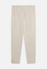 Pantalones de chándal beige claro hechos de una suave tela texturizada. Cuentan con una cintura elástica y piernas ajustadas con dobladillos con puños.