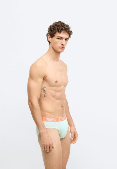 Cuecas masculinas de cor menta clara com uma cintura com logo laranja, feitas de tecido liso, apresentando um design ajustado e costuras mínimas.