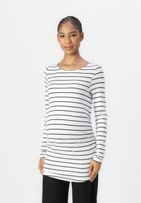 Camiseta de maternidad de manga larga en blanco con rayas horizontales negras. Cuenta con un escote redondeado y tejido elástico para mayor comodidad.