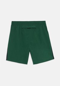 Shorts de sport vert foncé avec une taille élastique et un petit détail en noir sur le rabat de la poche arrière.