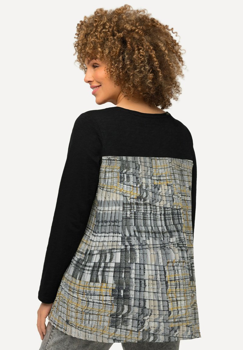 Zwarte lange mouwen top met een gestructureerde grijs-gele achterkant. Heeft een ontspannen pasvorm en subtiele plooien over het ontwerp.