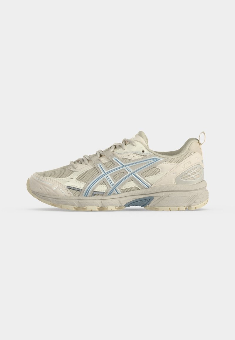 Zapatilla deportiva beige y azul claro con parte superior de malla y sintética, cierre de cordones, suela acolchada y lengüeta en el talón.