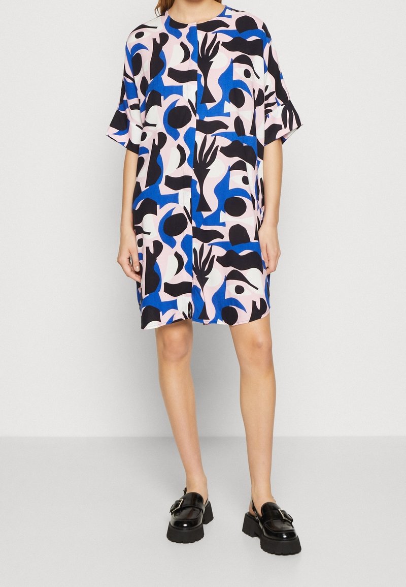 Vestido de manga corta en rosa, azul, negro y blanco con un patrón abstracto; corte relajado, hasta la rodilla, tejido suave, escote redondo, sin cierres.