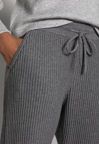 Grijze geribbelde joggingbroek met een trekkoord in de taille en zijzakken, met een zachte textuur en een gestroomlijnde pasvorm.