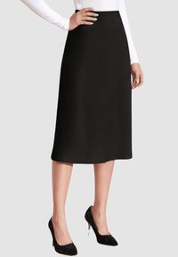 Falda negra midi con una textura suave, cintura alta y una silueta acampanada. Combinada con tacones altos negros para un look elegante.