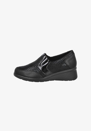 Zapato negro tipo slip-on que presenta un upper texturizado con un patrón de piel de serpiente, acentos brillantes y una puntera redondeada. Tiene un tacón de cuña bajo.