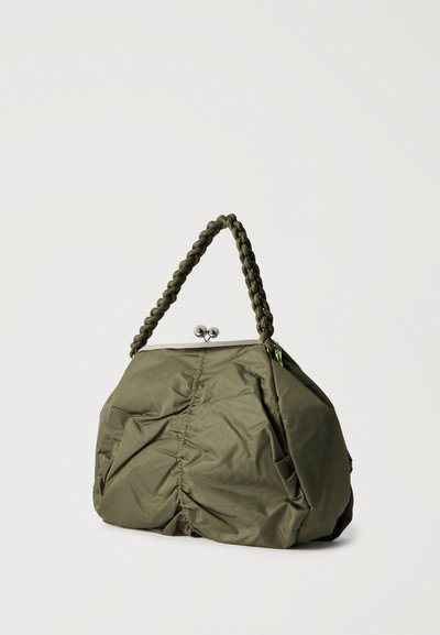 Τσάντα χειρός από ελιά πράσινο ύφασμα με ραμμένες πτυχές στο κέντρο, ασημένιο κούμπωμα τύπου kiss-lock και πλεγμένη λαβή σε λευκό φόντο.