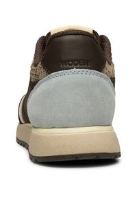 Braune Ledersneaker mit grauem Wildlederabsatz, gewebten Akzenten und beige Gummisohle. Merkmale von Branding auf der Rückseite.