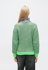 Zelený a sivý pletený sveter s vysokým golierom, zdobený textúrovaným vzorom, s rebrovanými manžetami a lemom.