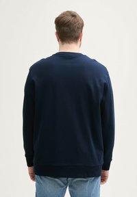 Marineblauer Langarm-Sweatshirt mit Rundhalsausschnitt, gerippten Bündchen und Saum. Glatte Stofftextur, minimales Design und keine sichtbaren Grafiken.