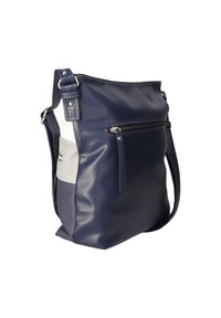 Sac à épaule bleu marine et blanc avec bandoulière réglable, poche zippée à l'avant et panneaux latéraux texturés.