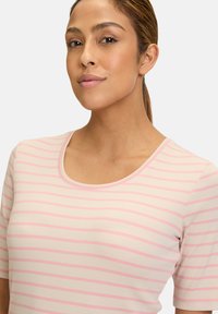 Light pink striped short-sleeve top with a rounded neckline, ribbed texture, and contrasting darker pink lines throughout.