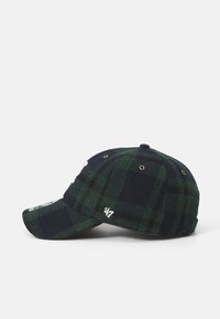 Rutete caps i mørkegrønn og marineblå ullblanding; har en buet skjerm, brodert logo og pustende øyer.