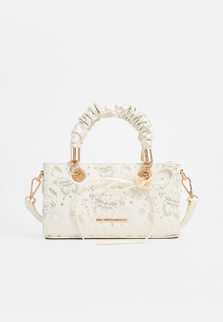 Sac en cuir crème avec poignée plissée, charme en forme de papillon doré, quincaillerie dorée, et design subtil de papillons et d'étoiles imprimés.