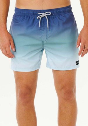 Uomo che indossa pantaloncini da bagno con gradiente dal blu al celeste, con coulisse bianca e una piccola toppa con logo nero sulla gamba sinistra.