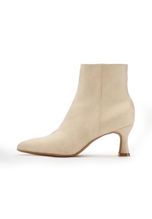 Beige Wildleder-Stiefelette mit spitzem Block, schlankem Absatz und glatter Textur. Verfügt über klare Linien und minimale Nähte für ein elegantes Erscheinungsbild.