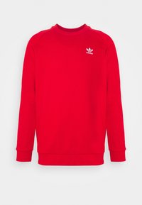 Felpa rossa in cotone con maniche lunghe, collo rotondo e polsini a costine. Presenta un logo Adidas bianco sul petto.