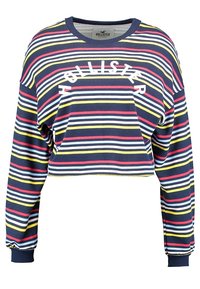 Randig kort sweatshirt i marinblått, med horisontella ränder i rött, gult och vitt, samt en vit "HOLLISTER"-logotyp på framsidan.