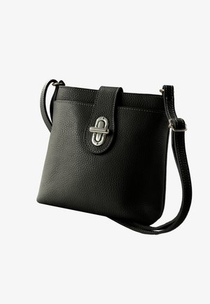 Zwarte, gestructureerde leren crossbodytas met zilveren draaiverluiting, verstelbare riem en witte contrasterende stiksels.