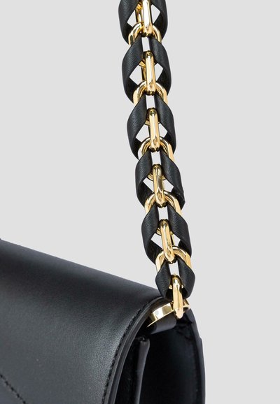 Borsa nera con finitura in pelle texturizzata, caratterizzata da una tracolla in catena realizzata con anelli intrecciati neri e oro, che mette in risalto i materiali a contrasto.