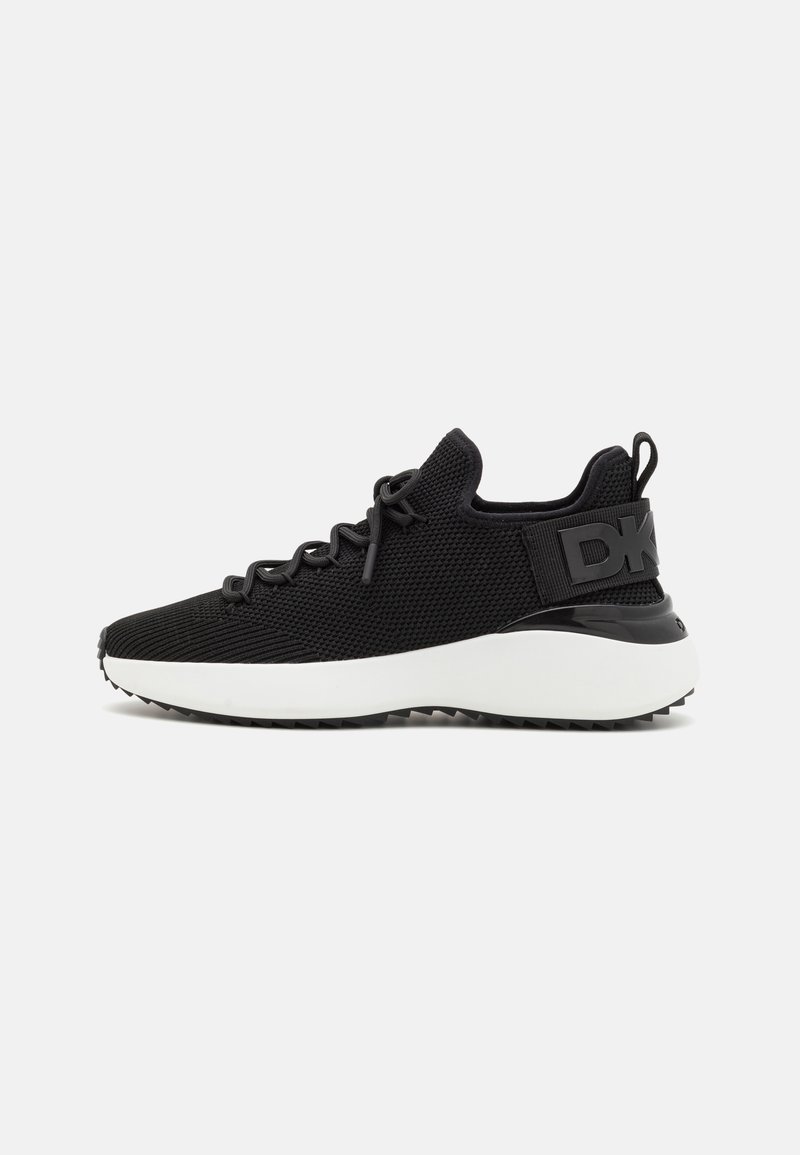 Scarpa sportiva nera con tomaia in mesh testurizzato, lacci elastici e suola bianca. Presenta un accento nero sul tallone con il logo.