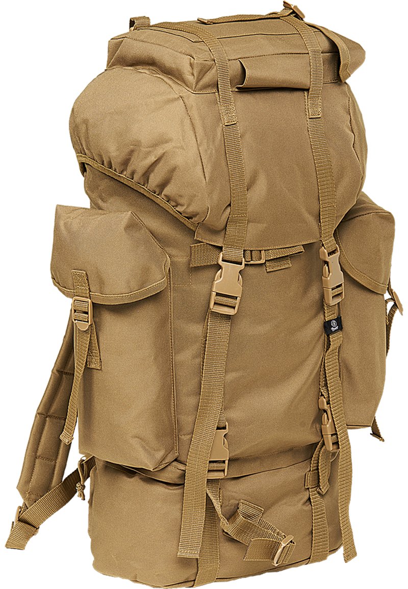 Sac à dos en tissu beige avec un rabat supérieur, plusieurs poches latérales, des bretelles réglables et des fermetures à boucle. Design robuste adapté à une utilisation en extérieur.
