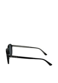 Occhiali da sole neri in plastica con lenti scure. Presentano un design elegante e arrotondato con dettagli in metallo silverate sulle alette, che mostrano il nome del marchio.