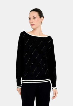 Maglione nero con un ampio scollo a barca, caratterizzato da linee diagonali e piccoli dettagli. Maniche e fondo a costine con righe bianche. Tessuto testurizzato.