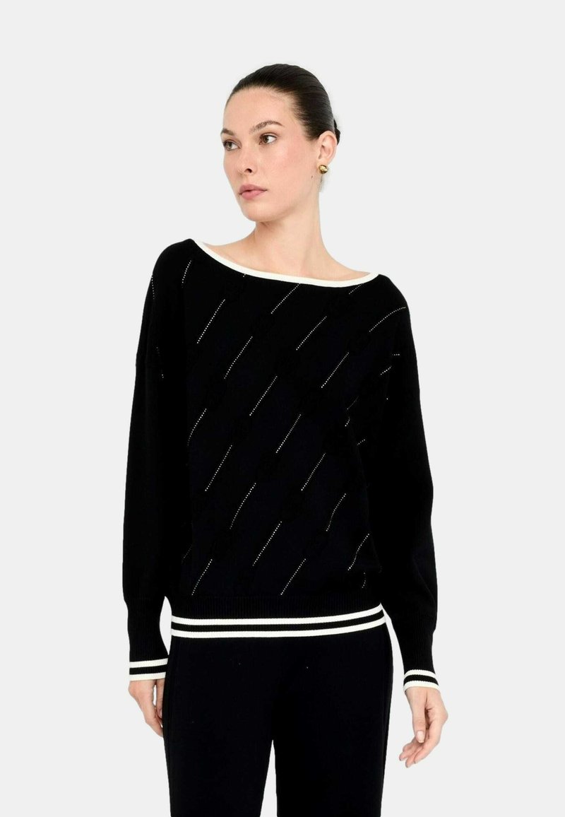 Maglione nero con un ampio scollo a barca, caratterizzato da linee diagonali e piccoli dettagli. Maniche e fondo a costine con righe bianche. Tessuto testurizzato.