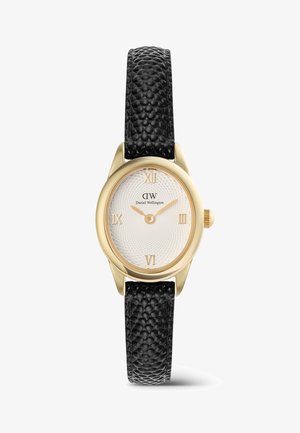 Zlaté kulaté hodinky s bílým texturovaným ciferníkem, černým texturovaným koženým řemínkem, římskými číslicemi na pozicích 12, 3, 6 a 9 a zlatými hodinovými a minutovými ručičkami.