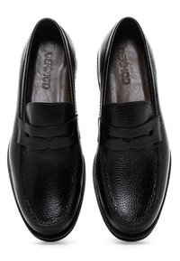 Black leather loafers with a textured finish, featuring a smooth strap across the vamp and a rounded toe. Subtle branding inside.
