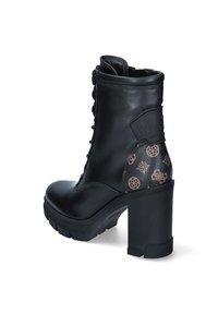 Botte de cheville en cuir noir avec un talon haut massif, un laçage à l'avant et un panneau arrière texturé arborant un logo discret et un motif géométrique.