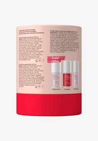 Topcoat verpakking, cilindervorm, roze en rode kleur, informatieve labels met ingrediënten, en drie kleine nagellakflesjes tentoongesteld.