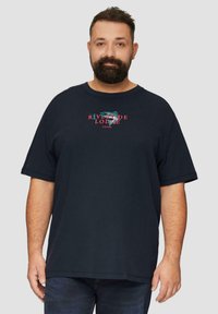 Marineblauwe katoenen T-shirt met korte mouwen, ronde halslijn, met een grafisch ontwerp met de tekst "RIVERSIDE LODGE" in kleurrijke accenten.