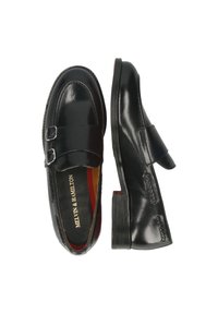 Svarta läderloafers med dubbel spänne och en låg, rektangulär klack, med sömnadsdetaljer och röd innerfoder.