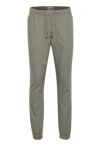 Spodnie dresowe w kolorze oliwkowej zieleni wykonane z lekkiego materiału, z elastycznym pasem ze sznurkiem i elastycznymi ściągaczami przy kostkach.