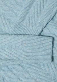 Jasnoniebieski sweter z dzianiny z teksturowanym wzorem w warkocze i ściągaczami. Materiał wydaje się miękki i przytulny.