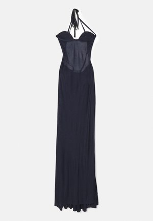 Dolga mornarsko modra obleka s prilegajočim bodicem in tekočim krilom, ki ima obliko halter vratu in prosojne panele. Gladka tekstura, minimalističen slog.