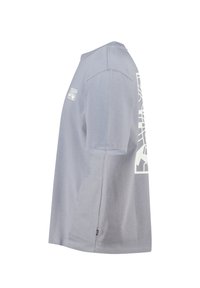 T-shirt en coton gris à manches courtes, présentant un design graphique blanc sur la manche gauche et un logo en patch sur la poitrine.