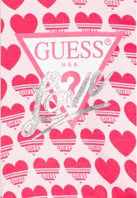 Tessuto rosa con cuori rossi ripetuti e righe orizzontali. Logo centrato all'interno di un triangolo, con la parola "Love" in una scritta argentata lucida.