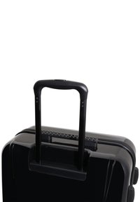 Black hard-shell suitcase with a telescopic handle, textured grip, and zipper closure. Smooth surface with no visible patterns or accents.