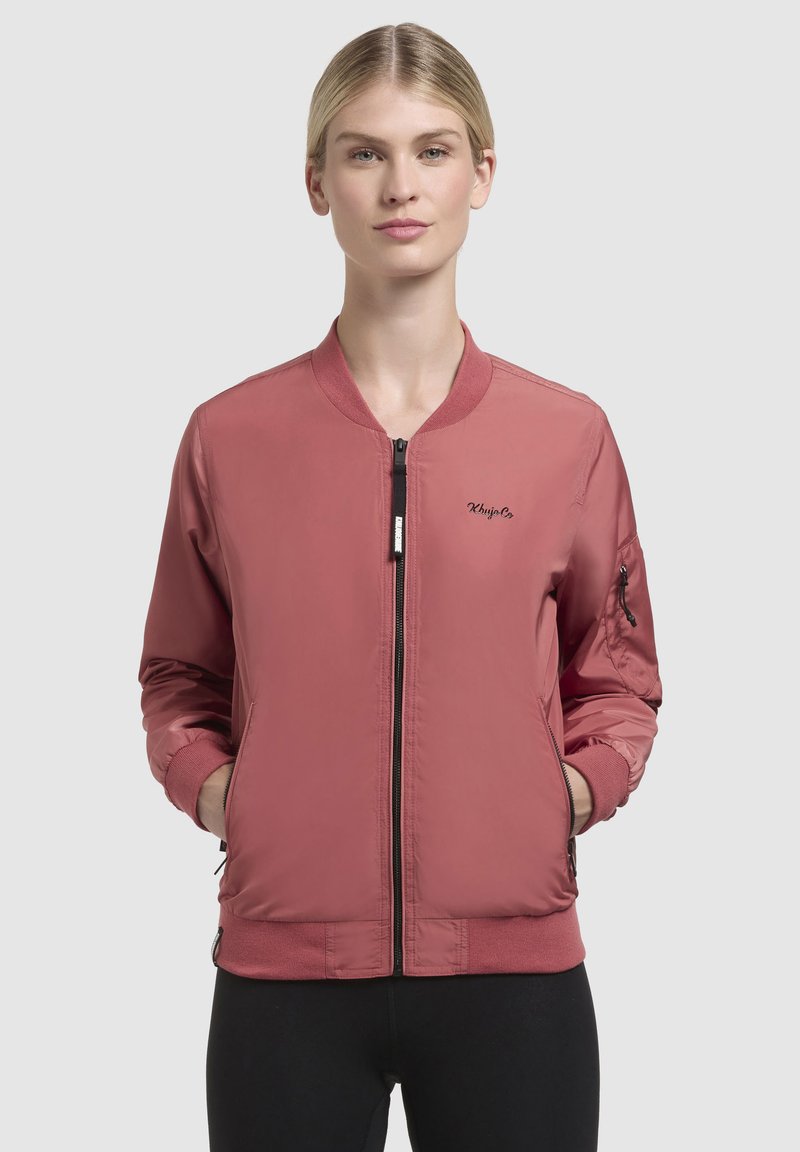 Roze bomberjack met geribbelde kraag en manchet. Heeft een ritssluiting aan de voorkant, zijzakken en een geborduurd logo op de borst.