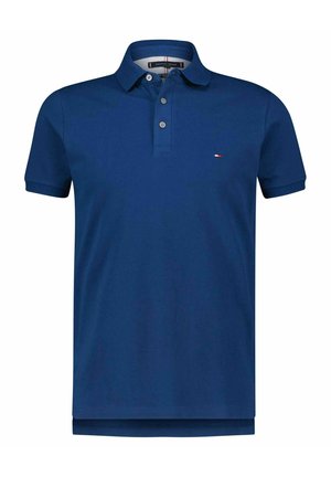 Polo de manga corta en azul marino con tres botones y un pequeño logo en rojo, blanco y azul en el pecho izquierdo.