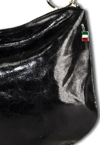 Zwarte laarzen van patenter leder met een zachte, gekreukte textuur. Voorzien van een grote gouden ring en een klein Italiaans vlaggetje als bedel.