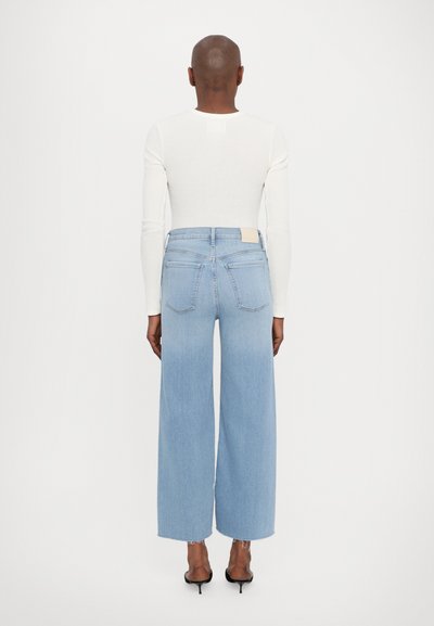 Šviesiai mėlynos plačios kojų džinsai, pagaminti iš džinsinio audinio, su aukštu liemeniu, nusidėvėjusiomis apyrankėmis ir dviem užpakalinėmis kišenėmis su minimalistišku ženklinimu.