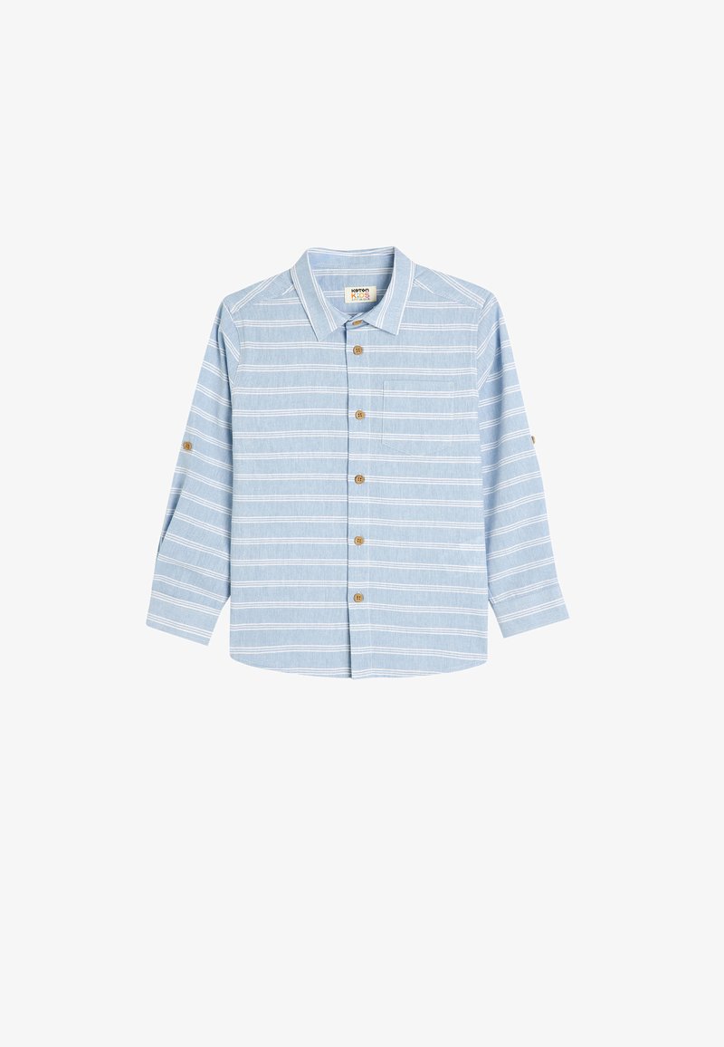 Camicia azzurra chiara con bottoni, caratterizzata da strisce orizzontali bianche, maniche lunghe, una tasca sul lato sinistro e bottoni marroni.