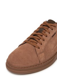 Adidași din suede maro, cu vârful rotunjit, închidere cu șireturi și șireturi maro. Au un superior texturat și o talpă groasă din cauciuc maro.