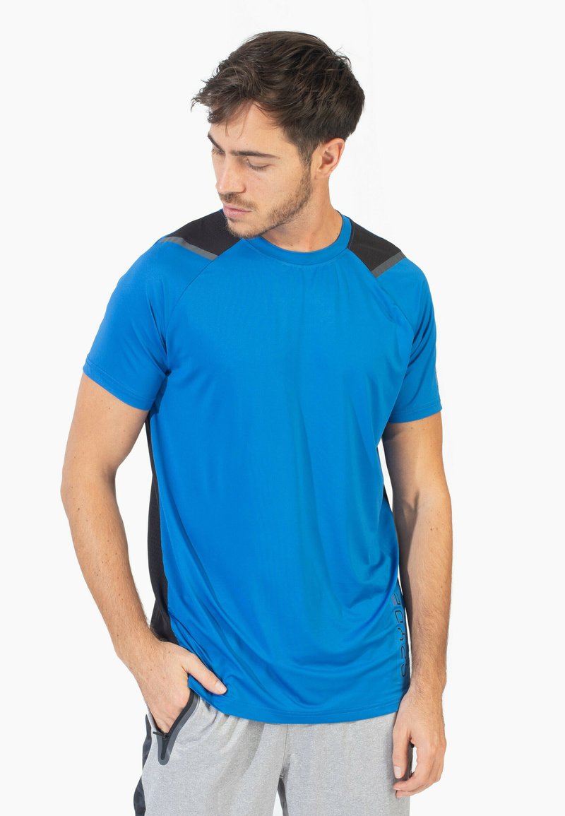 Camisa deportiva de manga corta en azul brillante, con acentos negros en los hombros y paneles laterales, con una textura de tela suave y que absorbe la humedad.